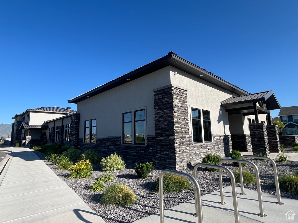 View of property exterior with stucco siding and stone siding