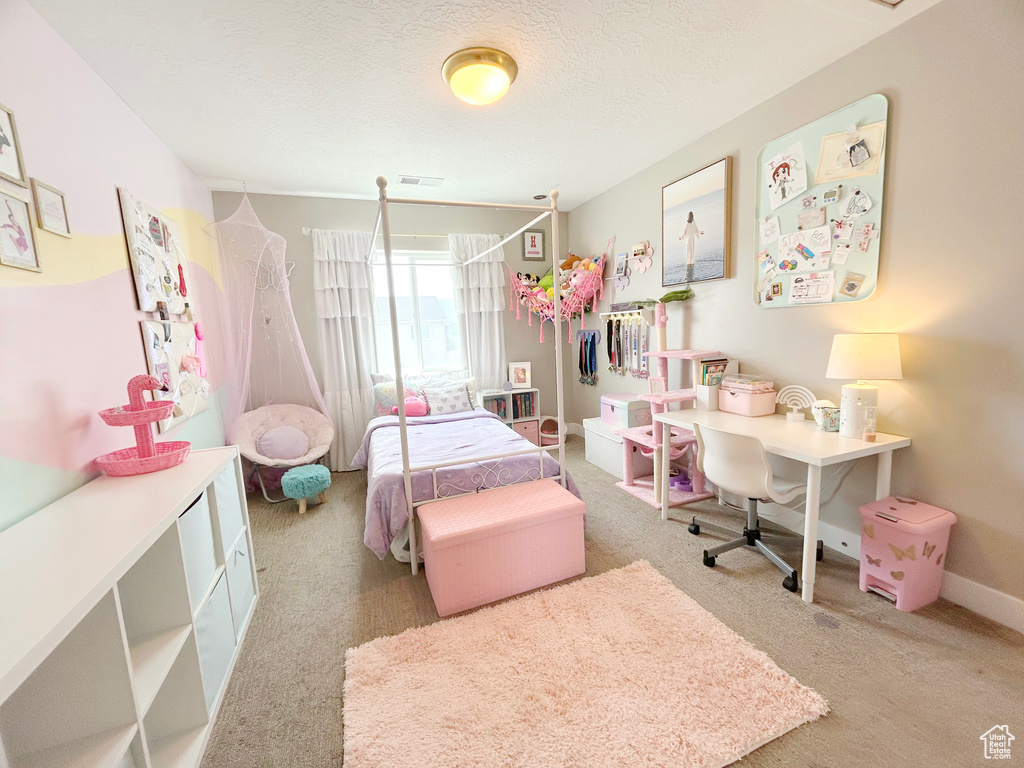 Carpeted bedroom featuring a textured ceiling and baseboards