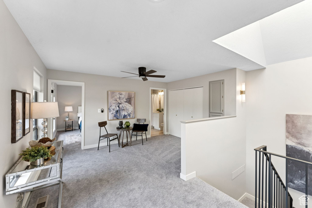 Interior space featuring an upstairs landing, carpet flooring, and baseboards