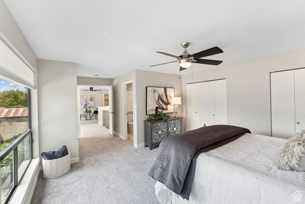 Bedroom featuring carpet flooring, multiple closets, baseboards, and a ceiling fan