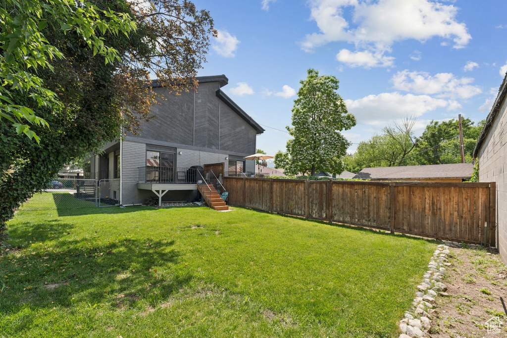 View of yard featuring a wooden deck and stairway