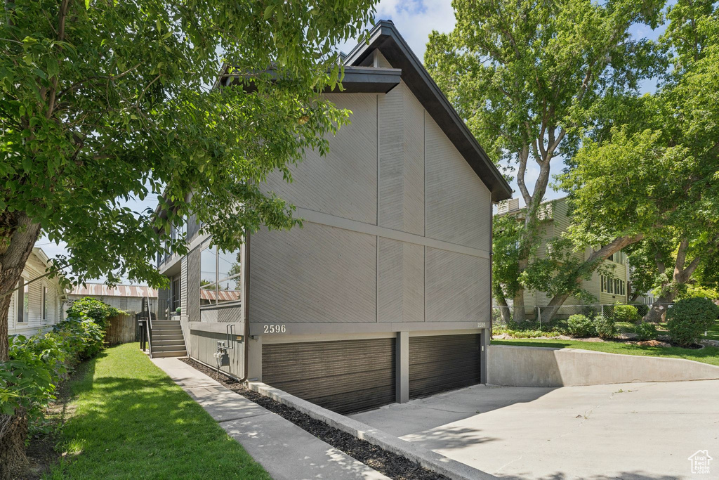 View of side of property with asphalt driveway and an attached garage