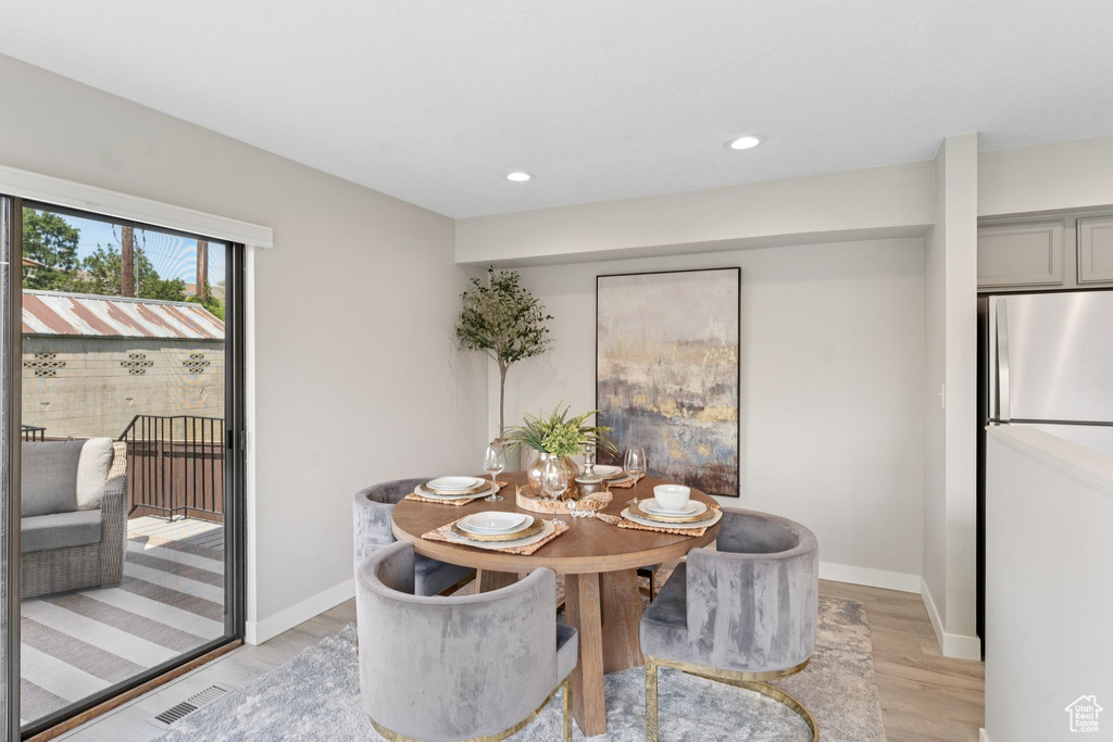 Dining area with light wood finished floors, recessed lighting, and baseboards