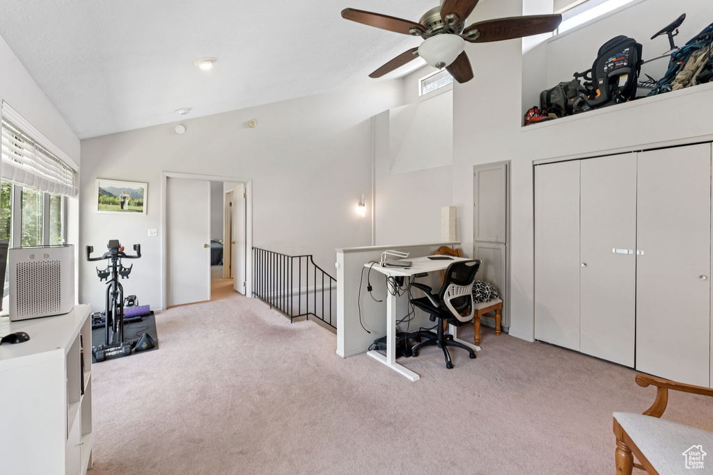 Office featuring light colored carpet, ceiling fan, and high vaulted ceiling