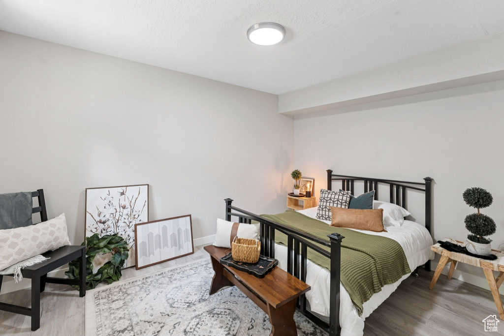 Bedroom with wood finished floors and baseboards