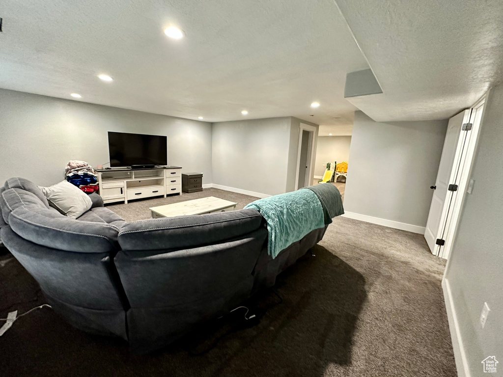 Living room featuring carpet, recessed lighting, baseboards, and a textured ceiling