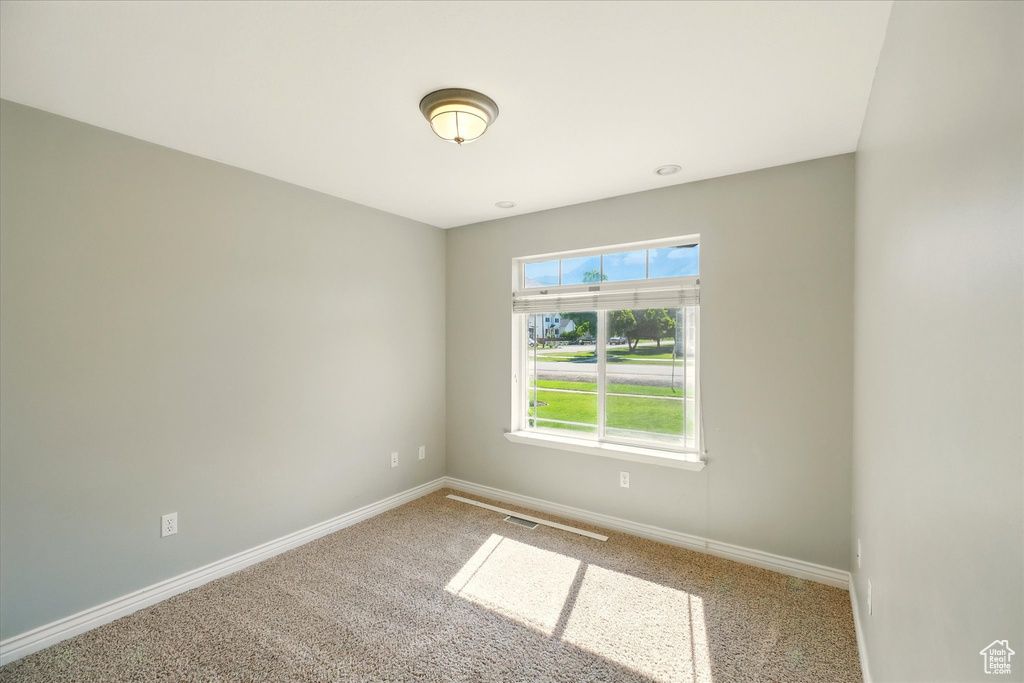 Spare room featuring carpet floors and baseboards