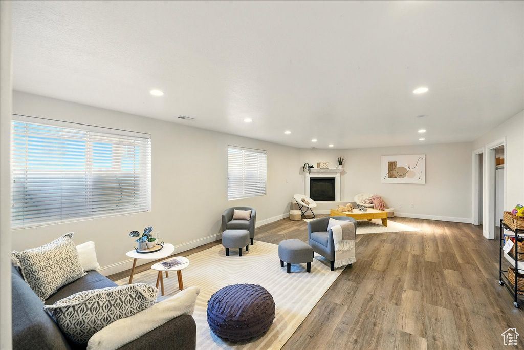 Living room featuring recessed lighting, wood finished floors, baseboards, and a glass covered fireplace
