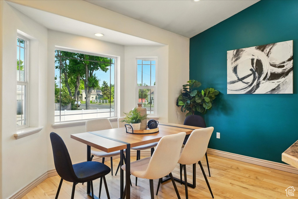 Dining room with healthy amount of natural light, wood finished floors, baseboards, and recessed lighting