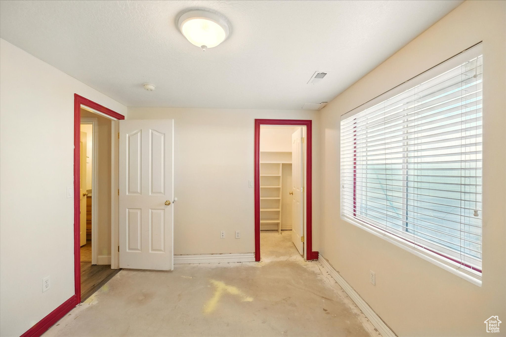 Unfurnished bedroom with a spacious closet, baseboards, and a closet