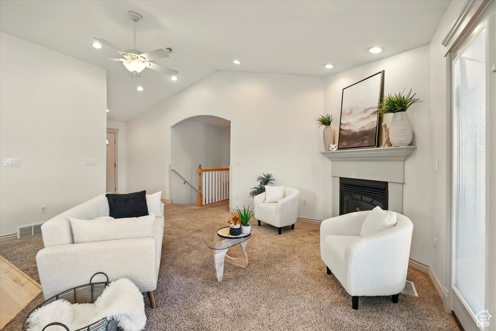 Living room with carpet floors, ceiling fan, arched walkways, lofted ceiling, and recessed lighting