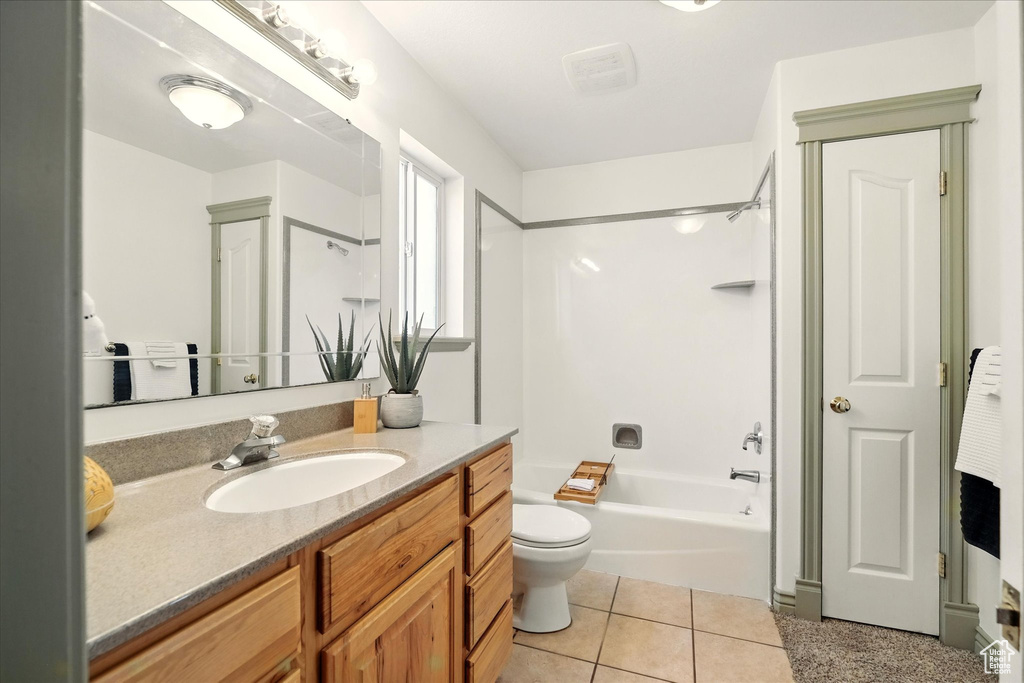 Bathroom with toilet, vanity, and shower / washtub combination