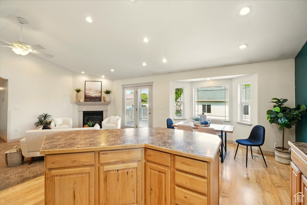 Kitchen with open floor plan, a fireplace, light wood-style floors, recessed lighting, and ceiling fan