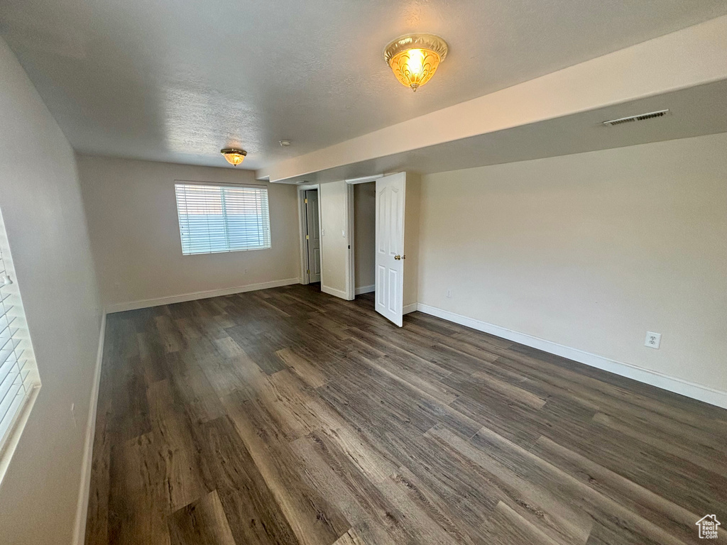 Unfurnished bedroom with dark wood-type flooring and baseboards