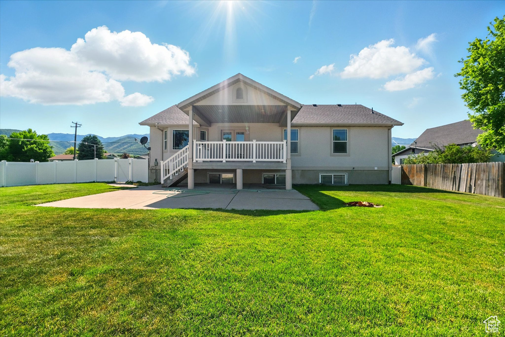 Rear view of house with a patio, a mountain view, and stucco siding