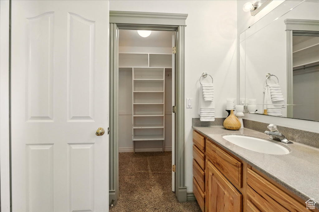 Bathroom featuring vanity and a spacious closet