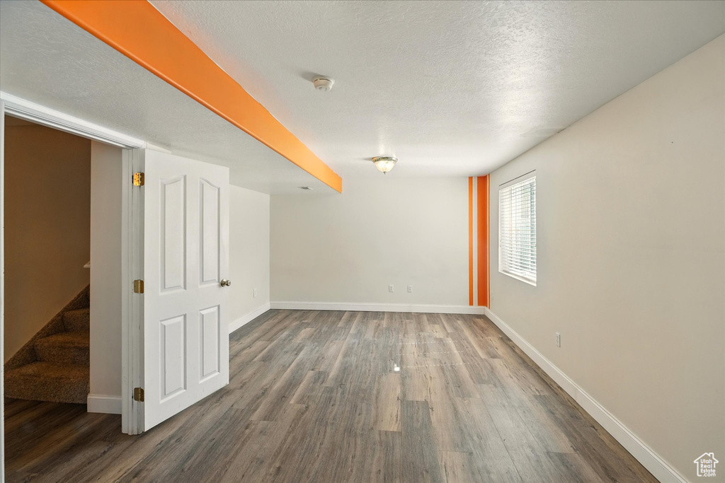 Spare room with wood finished floors, baseboards, and a smoke detector