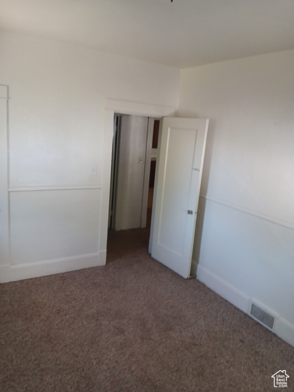 Carpeted empty room featuring baseboards