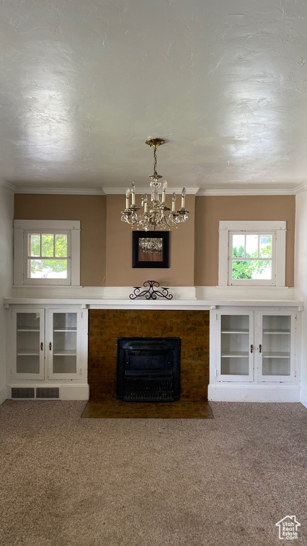 Living room featuring carpet floors, plenty of natural light, a chandelier, and ornamental molding