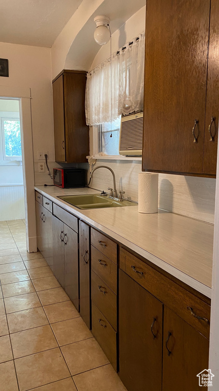 Kitchen with a sink, light tile patterned floors, and light countertops