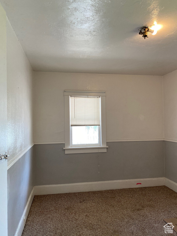 Spare room featuring carpet and baseboards