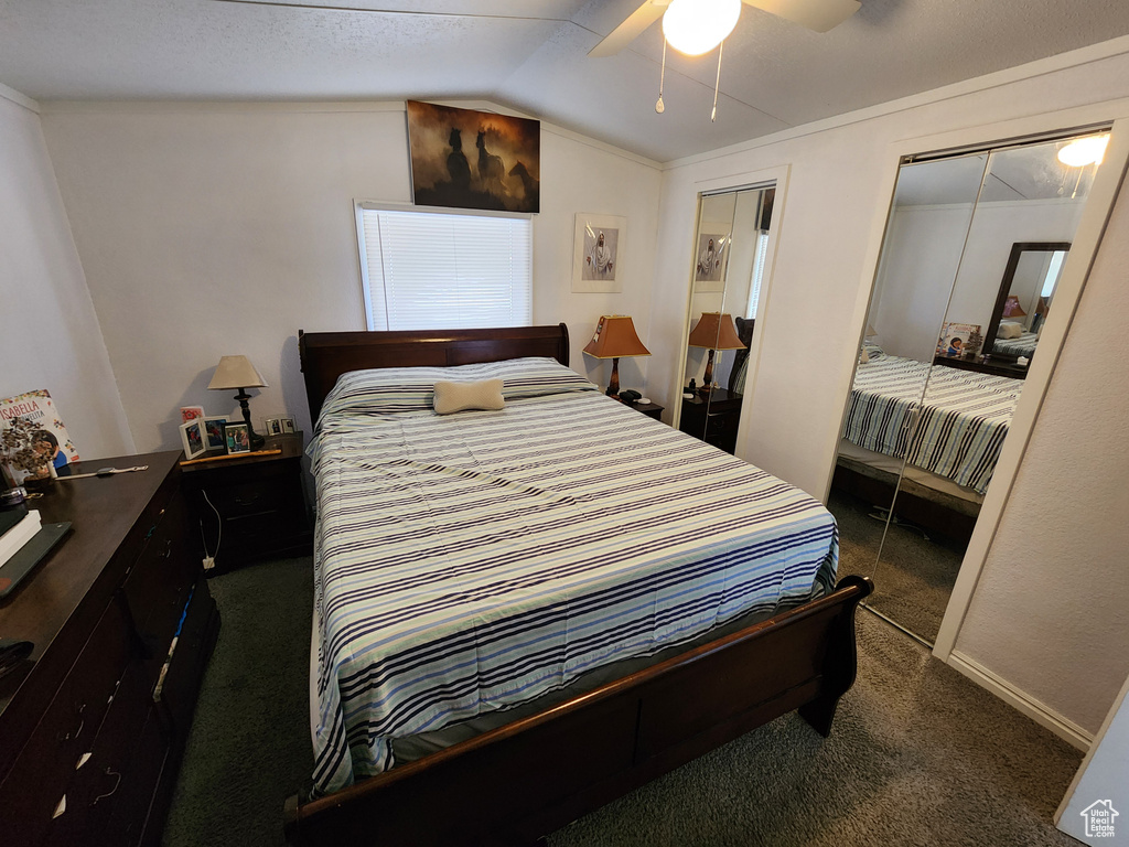 Carpeted bedroom featuring vaulted ceiling, a ceiling fan, and baseboards