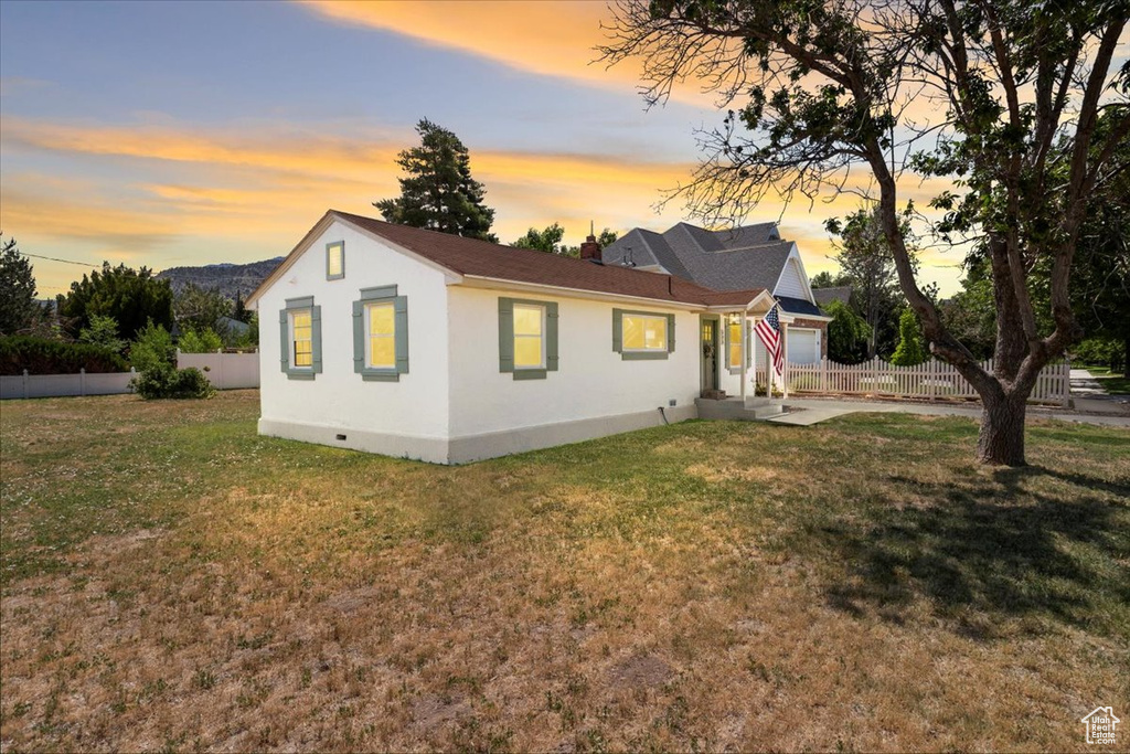 View of front of property with stucco siding, an attached garage, and driveway