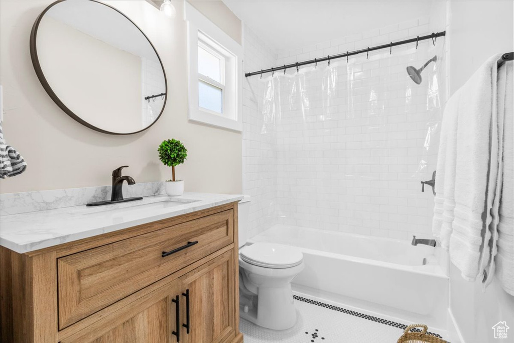 Full bathroom with vanity, toilet, shower / bath combination with curtain, and tile patterned floors