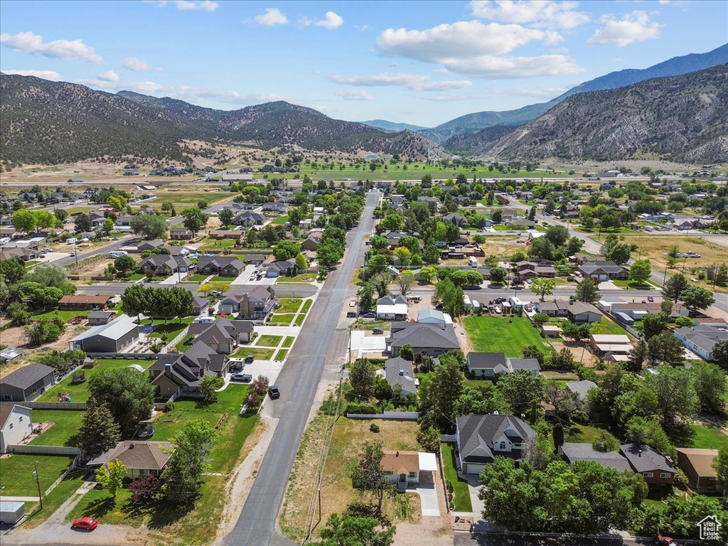 Aerial view of property and surrounding area with a mountainous background and nearby suburban area