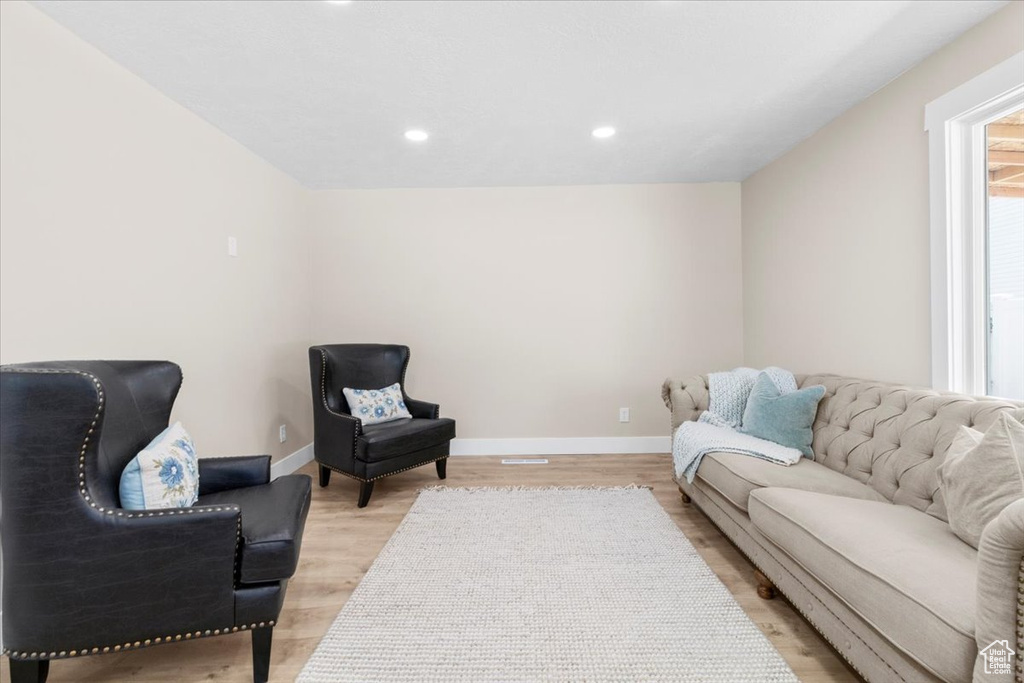 Living area featuring baseboards, light wood finished floors, and recessed lighting