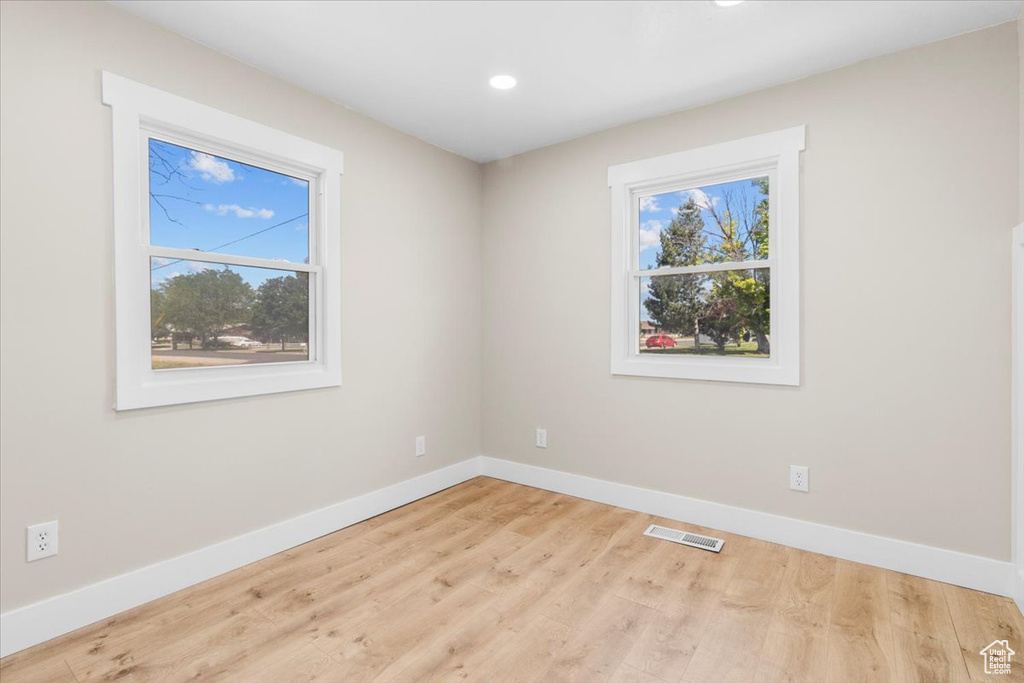 Unfurnished room featuring baseboards, healthy amount of natural light, recessed lighting, and wood finished floors