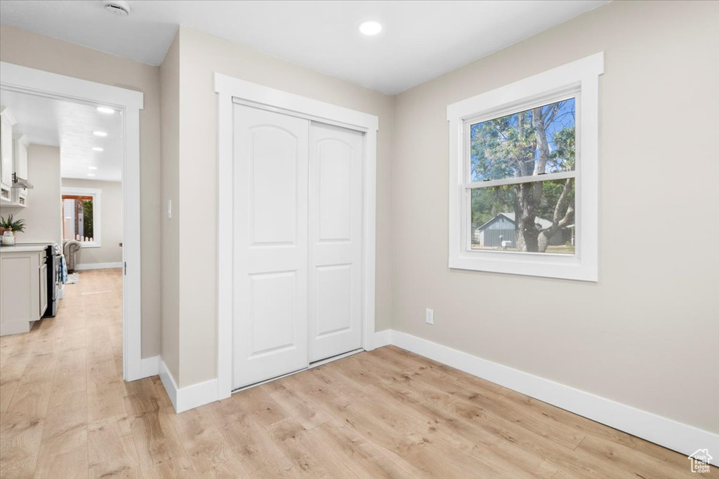 Unfurnished bedroom featuring baseboards, light wood-style flooring, recessed lighting, and a closet