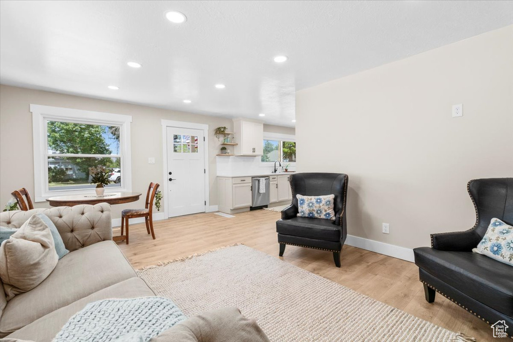 Living room featuring plenty of natural light, recessed lighting, baseboards, and light wood-style flooring