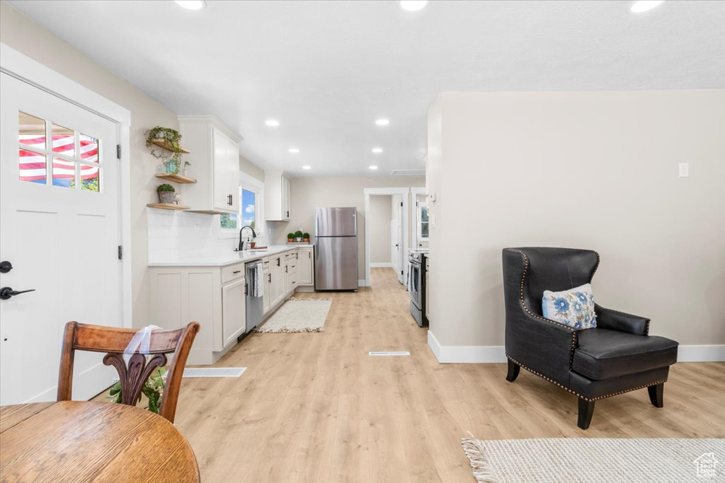 Kitchen featuring appliances with stainless steel finishes, light countertops, baseboards, light wood-style flooring, and recessed lighting