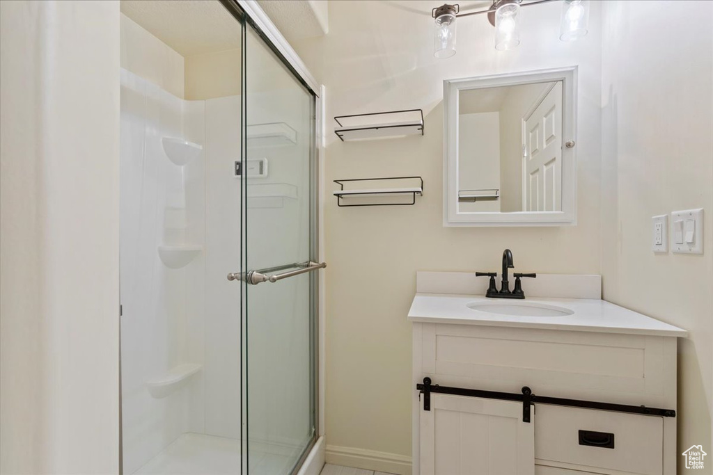 Full bath featuring a shower stall and vanity