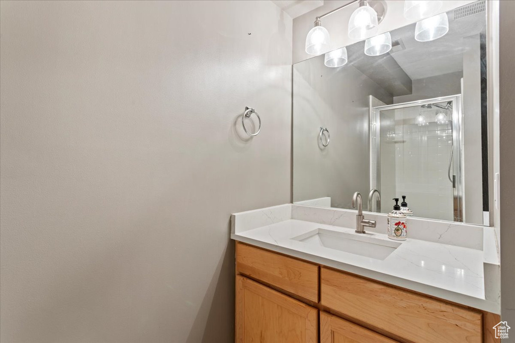 Full bathroom with vanity and a shower stall