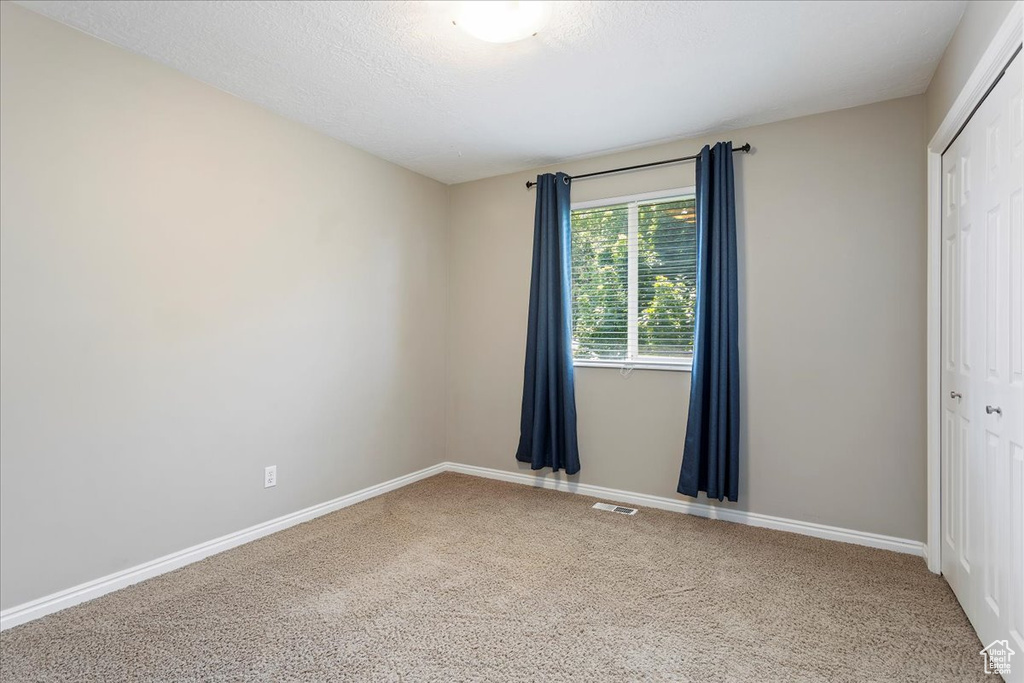 Unfurnished bedroom featuring a closet, carpet floors, and baseboards