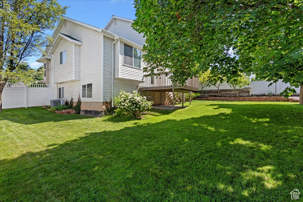 View of yard featuring a wooden deck and cooling unit