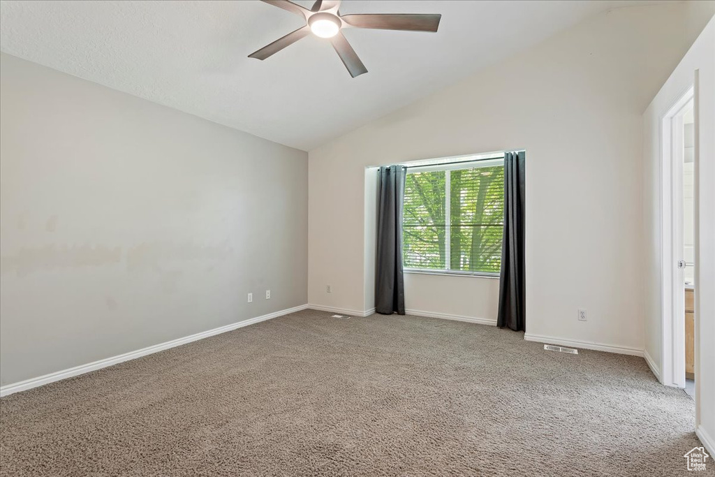 Unfurnished bedroom with vaulted ceiling, carpet, baseboards, and ceiling fan