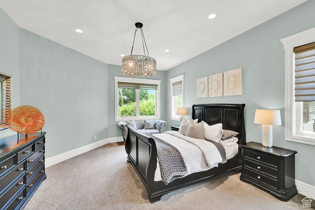 Bedroom featuring baseboards, a chandelier, light colored carpet, and recessed lighting