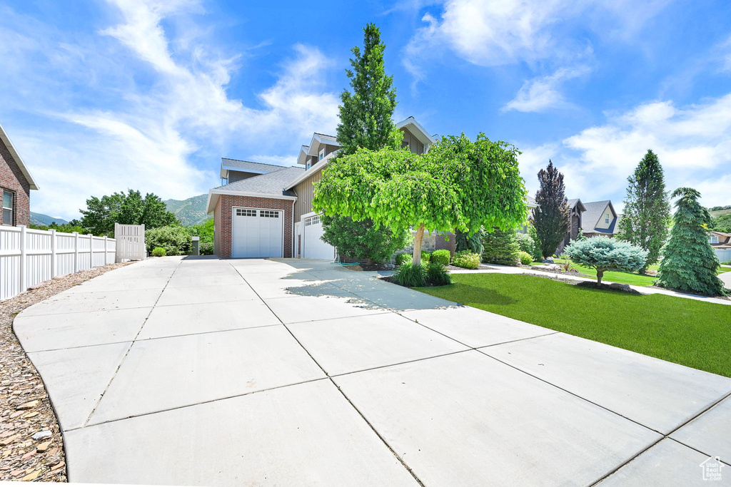 Obstructed view of property featuring driveway, a garage, and stucco siding