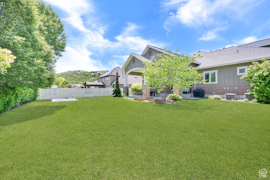View of yard with central air condition unit and a patio area