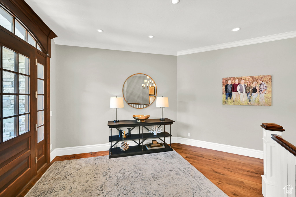 Foyer featuring ornamental molding, baseboards, wood finished floors, and recessed lighting