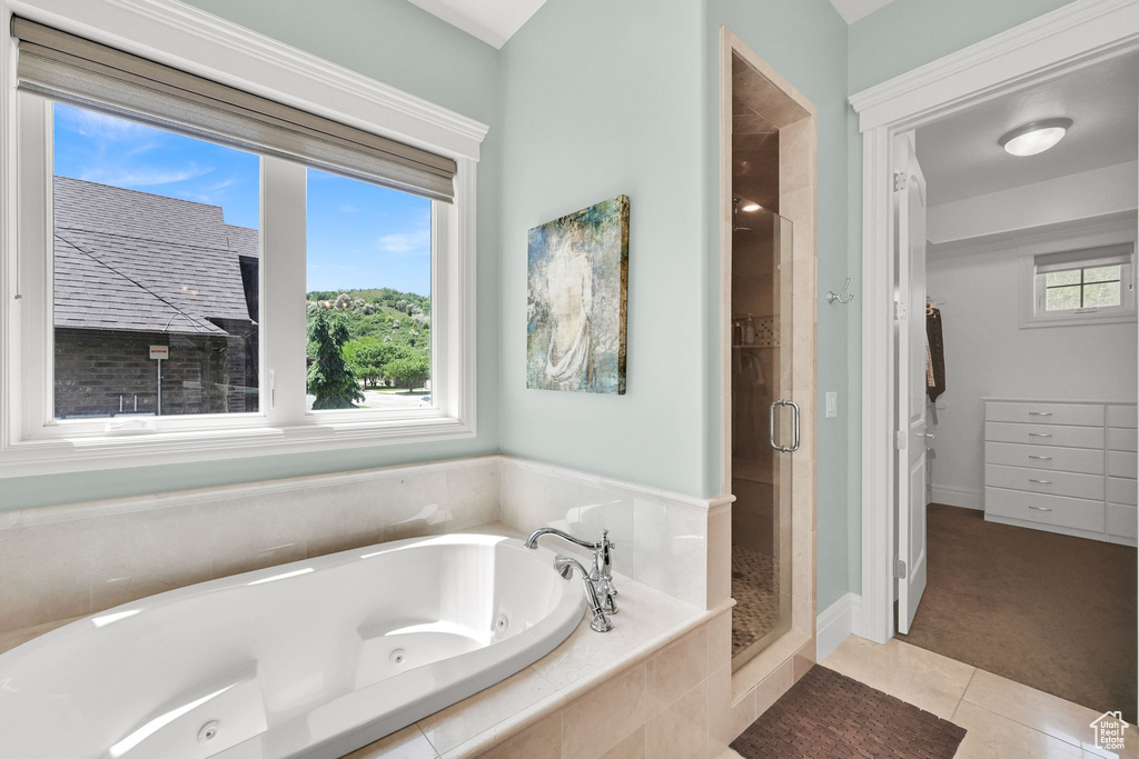 Bathroom with a shower stall, a jetted tub, and tile patterned flooring