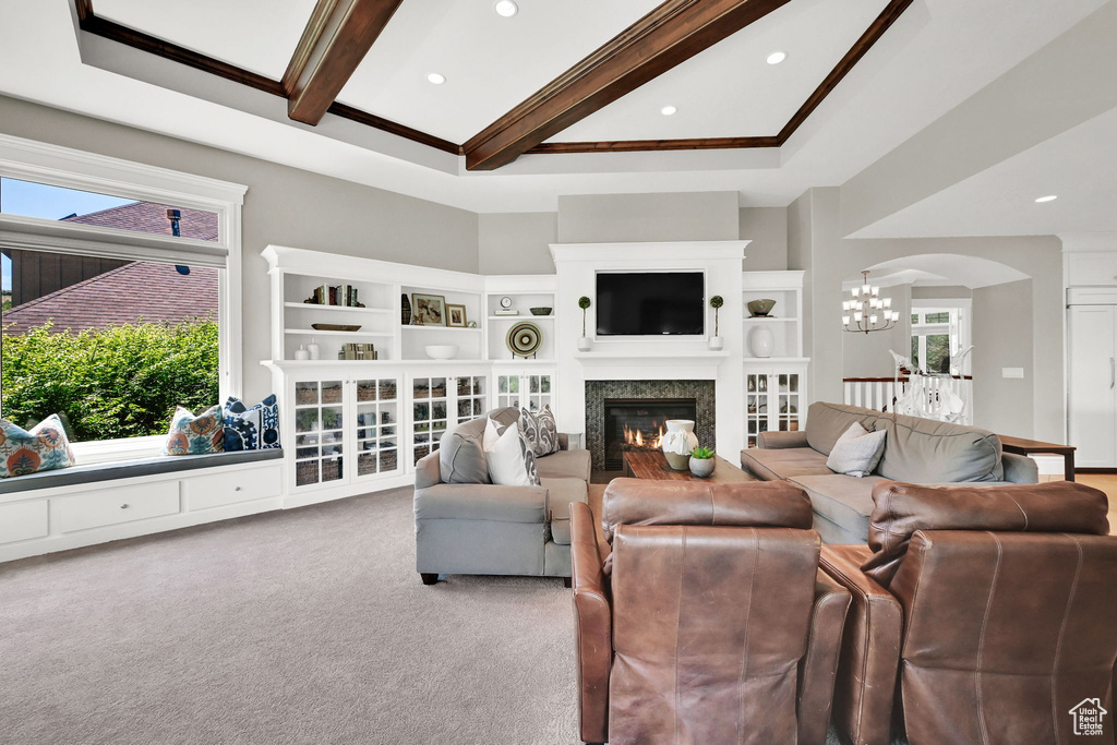 Carpeted living area with a chandelier, beamed ceiling, a glass covered fireplace, recessed lighting, and arched walkways