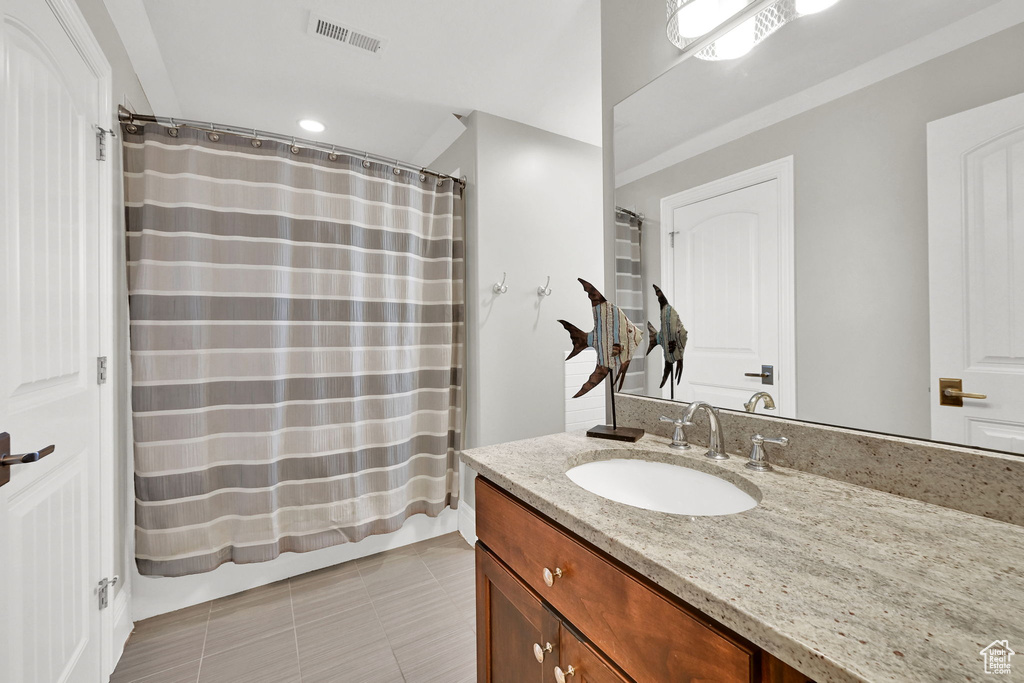 Bathroom featuring vanity, tile patterned flooring, and recessed lighting