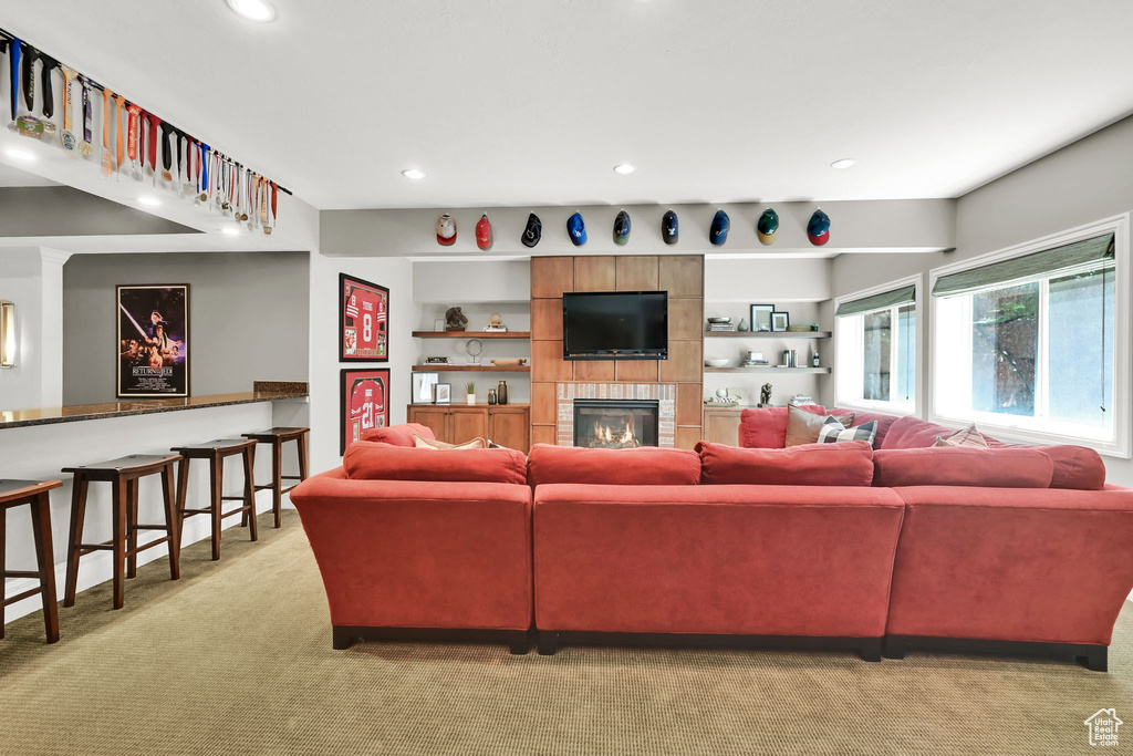 Living room with light carpet, recessed lighting, and a fireplace