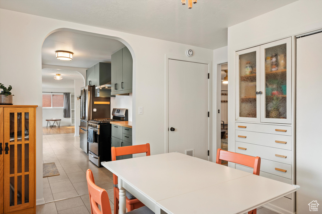 Dining area featuring arched walkways and light tile patterned flooring