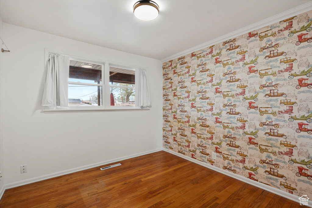 Empty room featuring wood finished floors and baseboards