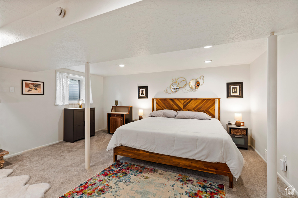 Bedroom with light colored carpet, baseboards, and recessed lighting
